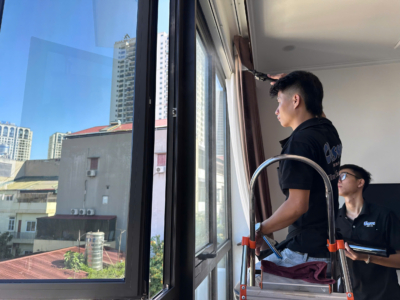 Kỹ thuật viên thi công phim cách nhiệt nhà phố trên cửa kính hướng Tây