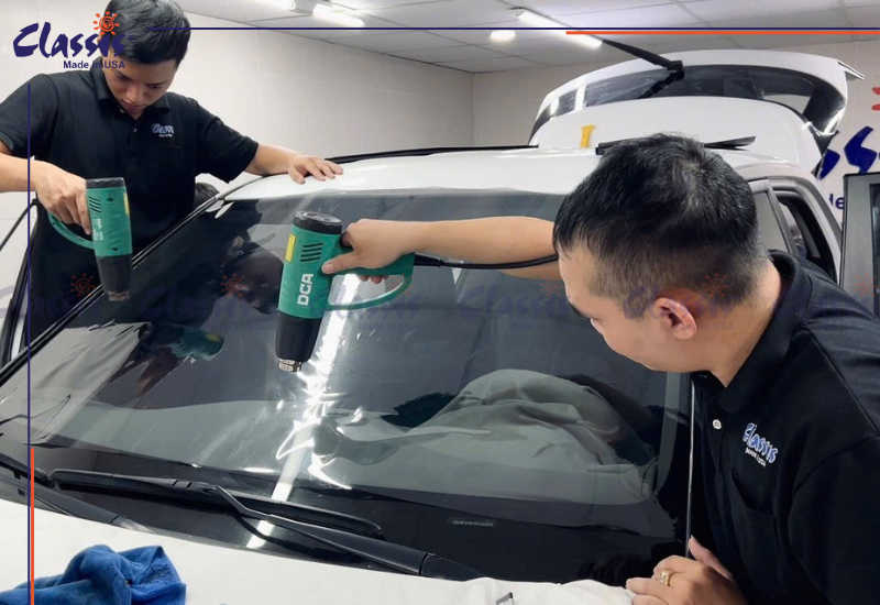 Kỹ thuật viên Toàn Tiến thi công phim cách nhiệt kính lái ô tô.